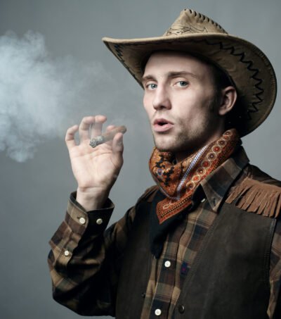 Artistic portrait of the young beautiful man. The young man smok